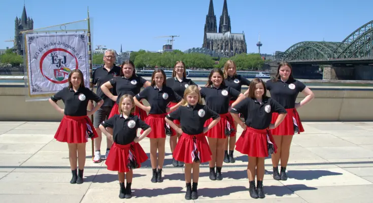 Die Tanzgruppe "Die Tanzenden Teufelchen" steht für ein Gruppenbild vor dem Kölner Dom angetreten.